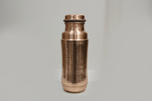 Copper water bottle with textured design on a marble surface