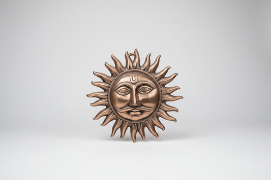 Bronze sun and moon wall art on a light gray wall