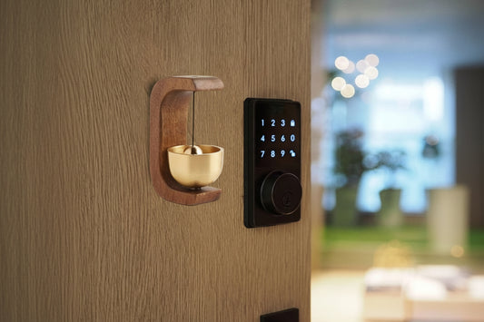 Smart lock on a wooden door with a decorative wooden holder and gold cup.