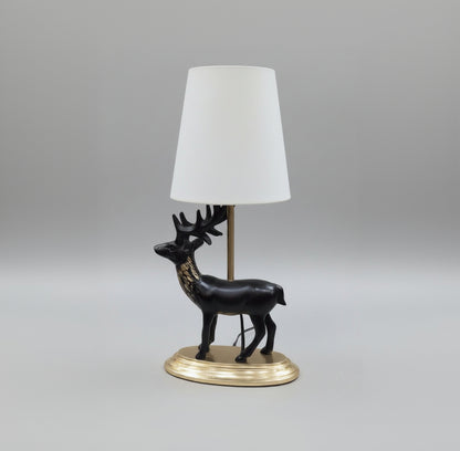 Decorative black horse figure on a pedestal with gold base, placed on a surface.