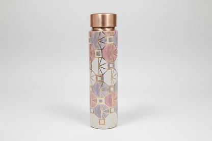 Decorative water bottle with geometric pattern and metallic accents on a tiled background