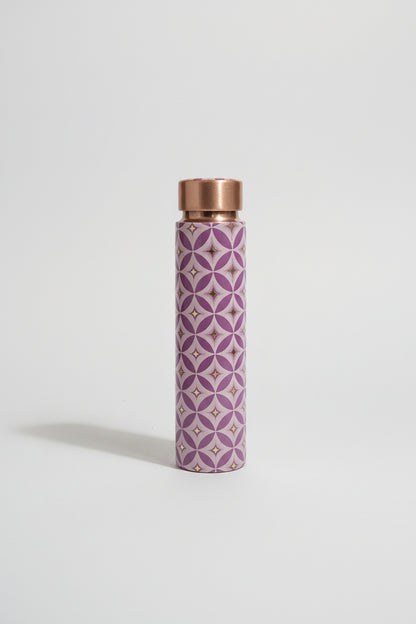 Purple patterned water bottle with copper cap on a tiled bathroom floor