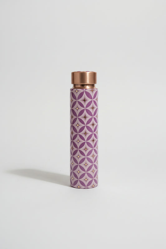 Purple patterned water bottle with copper cap on a tiled bathroom floor