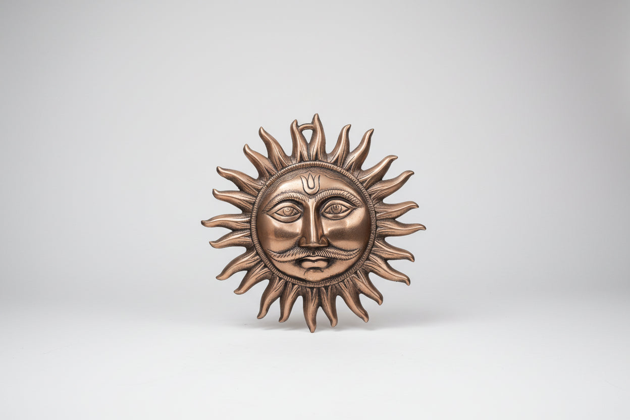 Bronze sun and moon wall art on a light gray wall