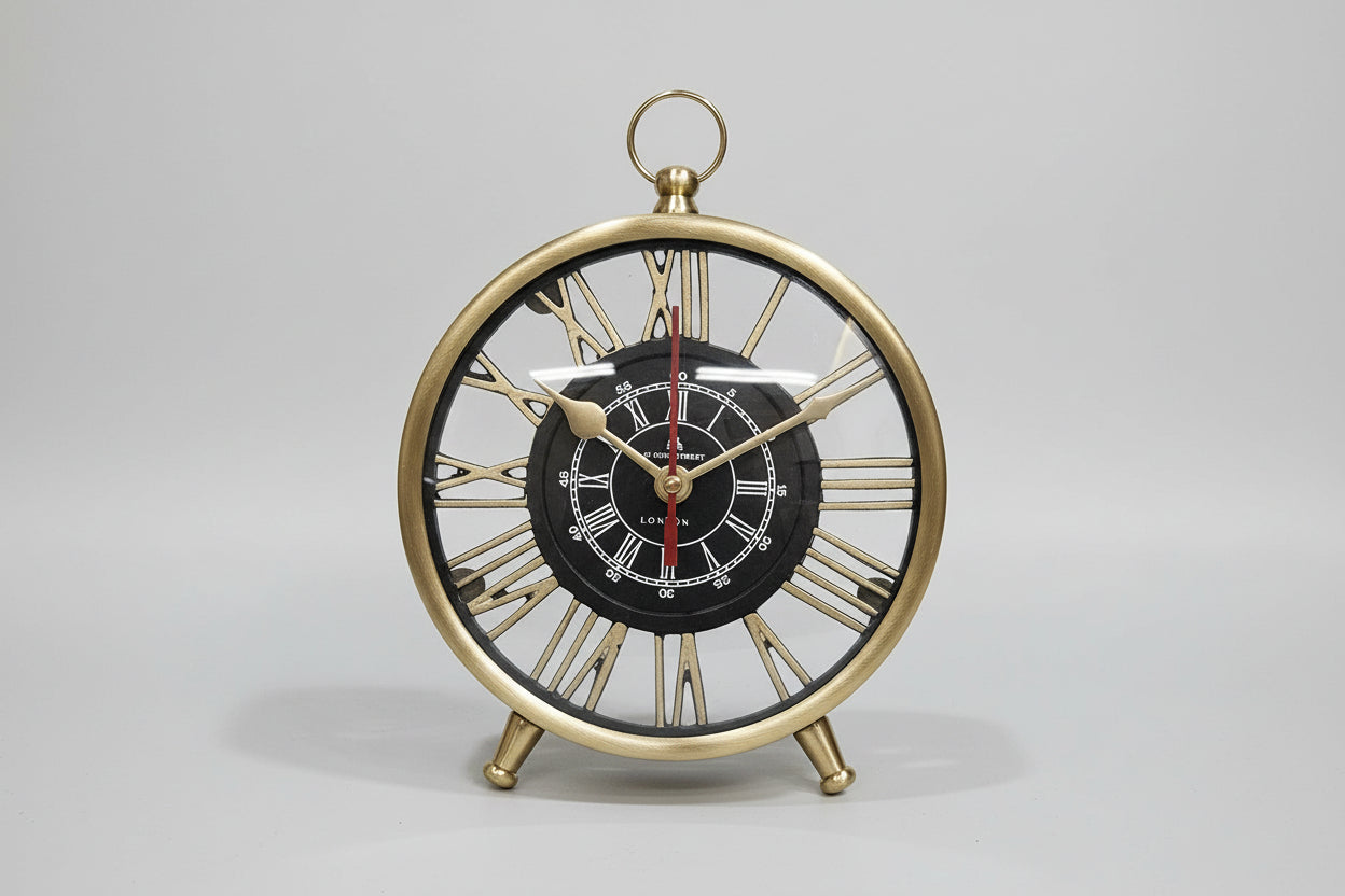 Decorative clock with gold frame and black face on a white wall.