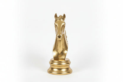 Gold horse head wall mount on a marble wall