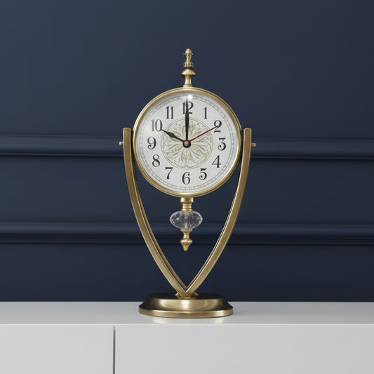 Decorative table clock with gold frame and white face on a dark blue background